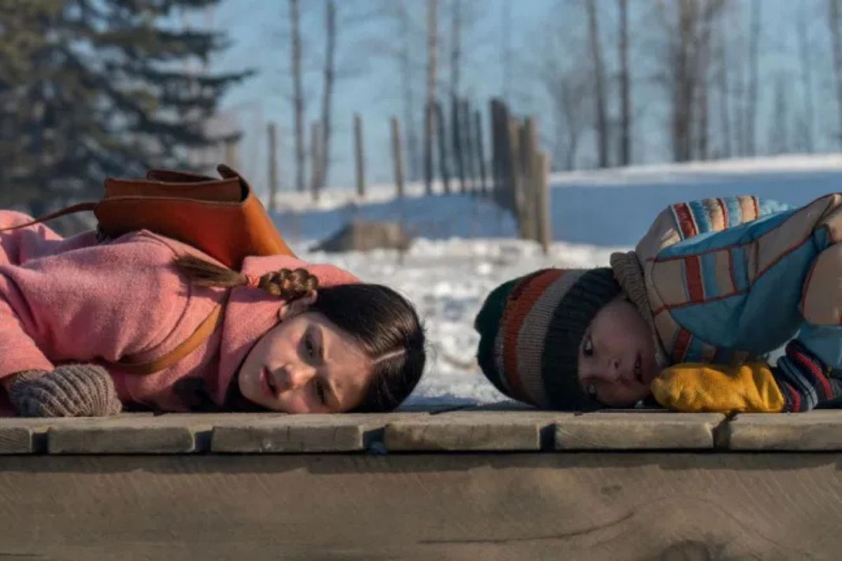 Tales from the Loop Prime Video - Madre e figlio sdraiati su neve paesaggio invernale Ohio atmosfera malinconica Simon Stålenhag