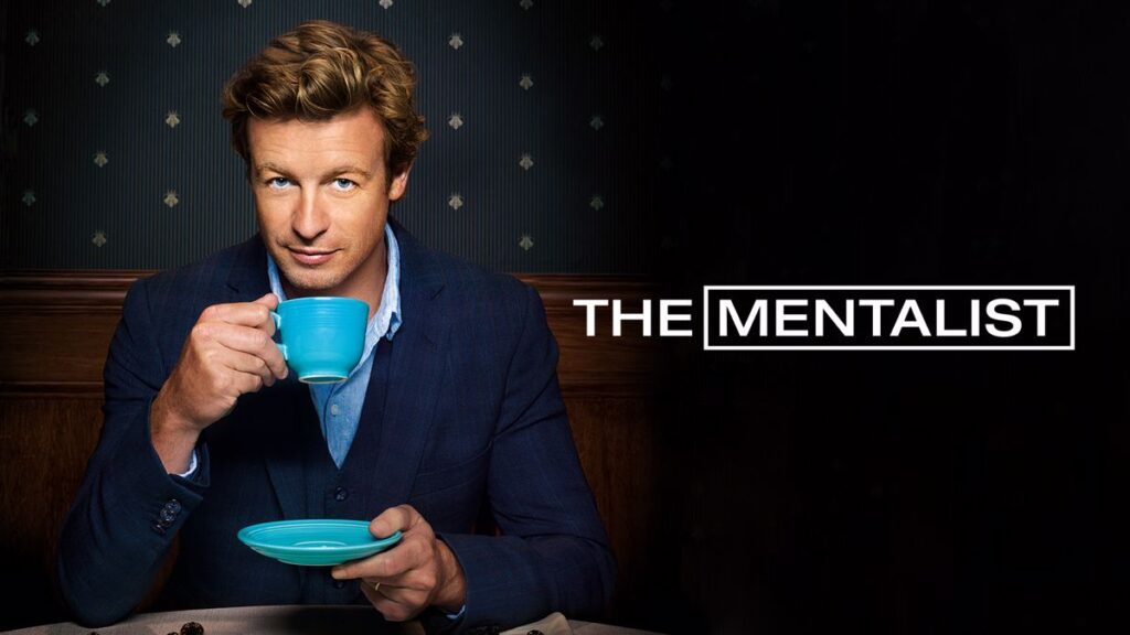 Home 1 Simon Baker come Patrick Jane in The Mentalist, che guarda l'obiettivo sorseggiando da una tazza azzurra.